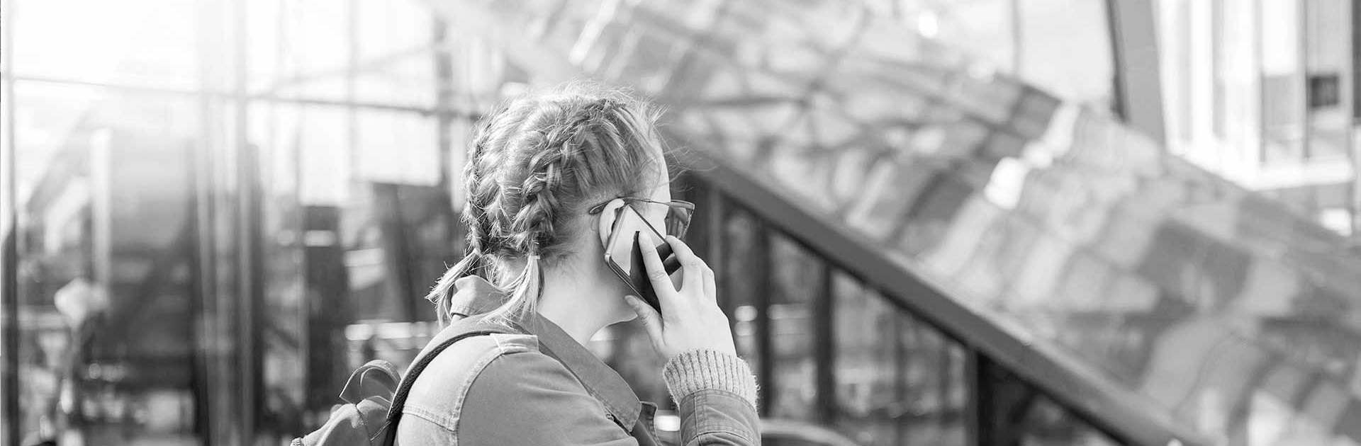 Svartvit bild på en kvinna som talar i telefon.